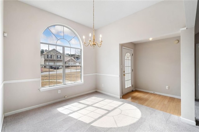 empty room with an inviting chandelier, baseboards, and carpet flooring