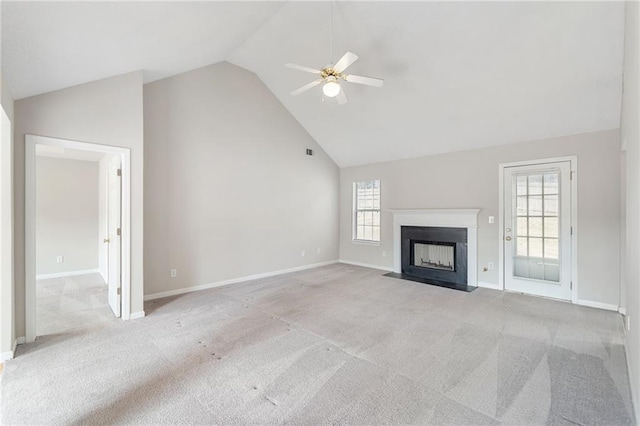 unfurnished living room with ceiling fan, high vaulted ceiling, light carpet, a fireplace with flush hearth, and baseboards