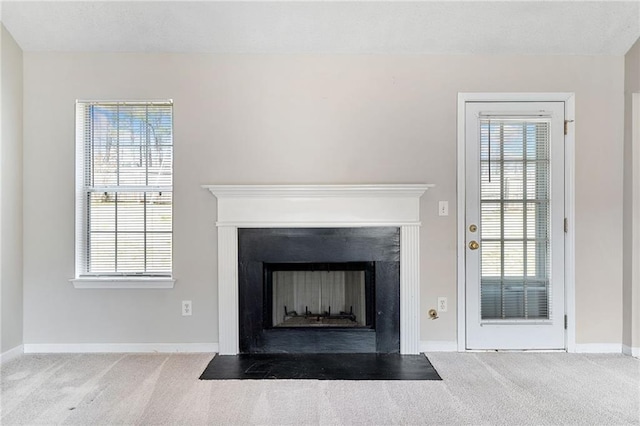 details featuring a fireplace with flush hearth, baseboards, and carpet flooring