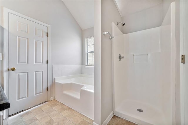 bathroom featuring lofted ceiling, a garden tub, and a walk in shower