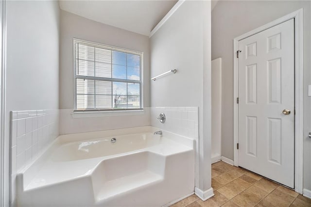 full bath featuring a garden tub, baseboards, and tile patterned floors