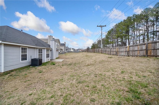 view of yard featuring fence and central AC unit