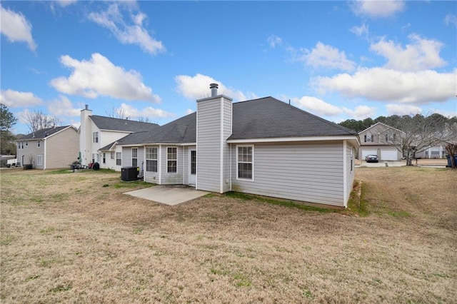 back of property featuring a patio area, central AC, a lawn, and a chimney