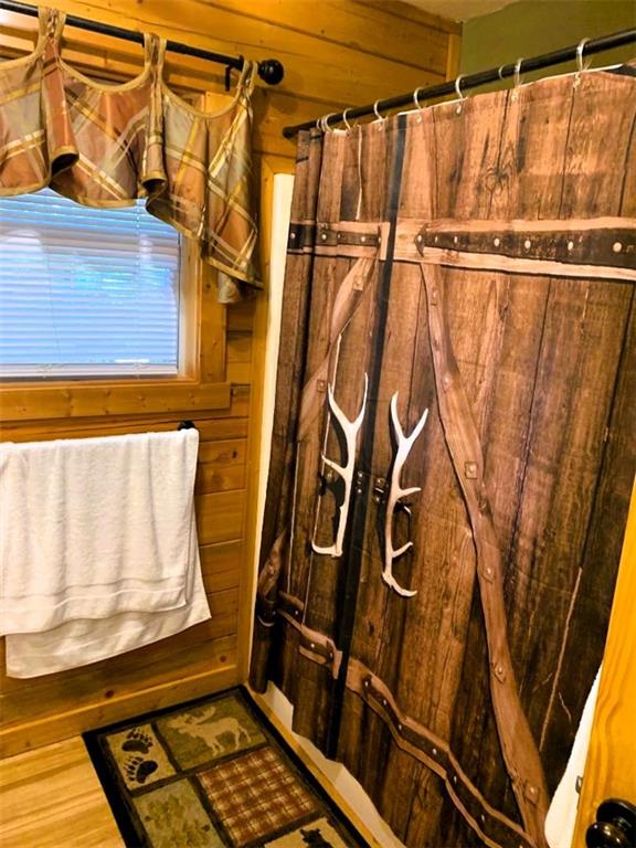 bathroom featuring wooden walls