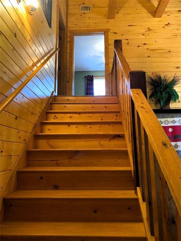 staircase featuring wooden walls