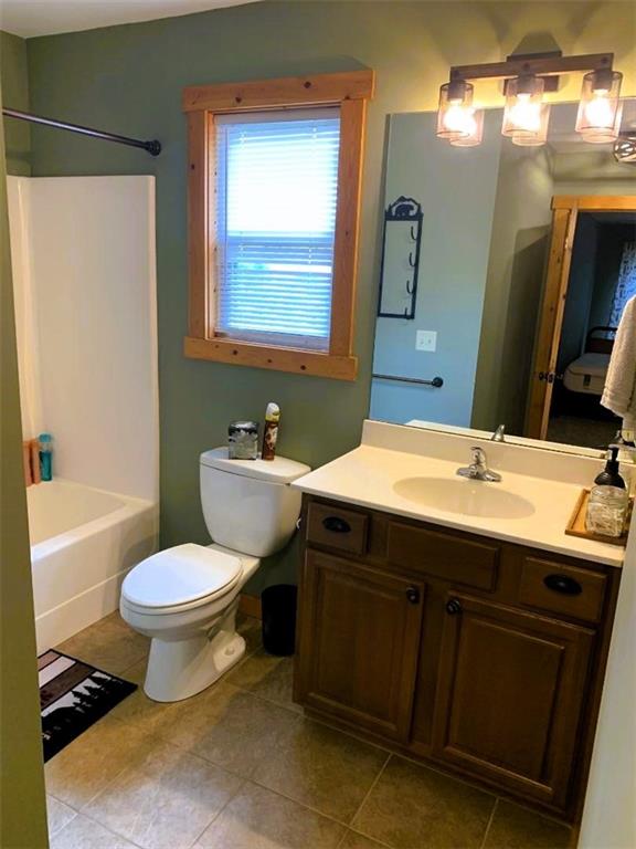 full bathroom featuring tile patterned flooring, vanity, shower / tub combination, and toilet