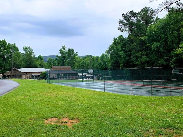 view of tennis court with a lawn