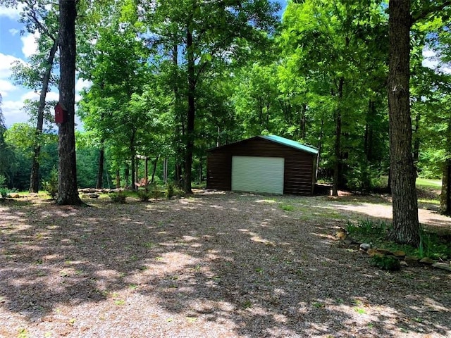 view of yard with a garage and an outbuilding