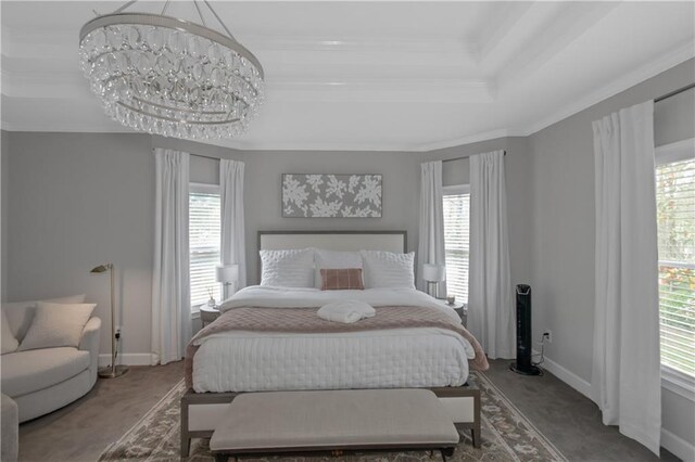 carpeted bedroom with baseboards, a raised ceiling, and multiple windows