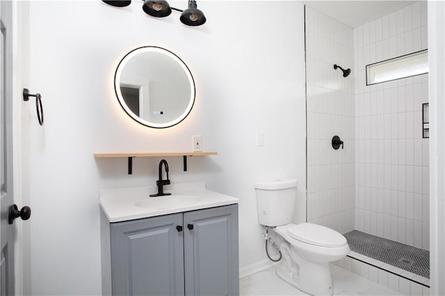 bathroom with a tile shower, vanity, baseboards, toilet, and marble finish floor