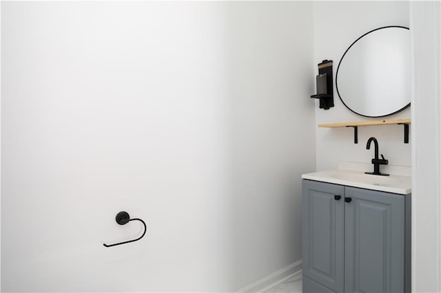 bathroom with baseboards, marble finish floor, and vanity