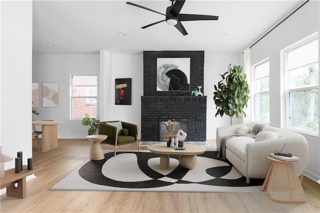 living room featuring recessed lighting, ceiling fan, wood finished floors, and a fireplace