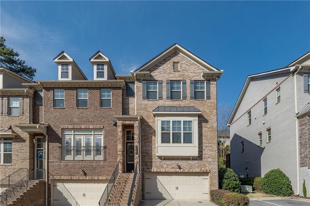 view of property featuring stairs, driveway, brick siding, and an attached garage