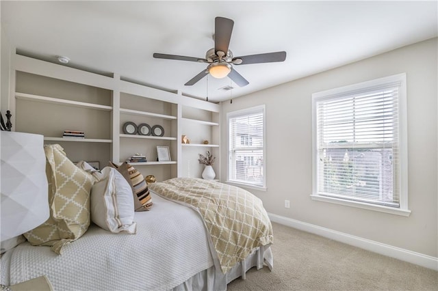 bedroom with baseboards, a raised ceiling, and light colored carpet