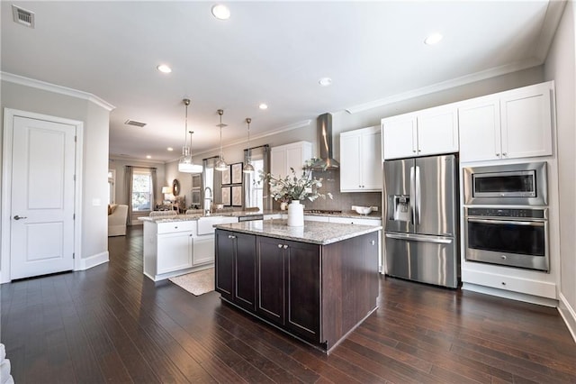 kitchen with visible vents, a peninsula, appliances with stainless steel finishes, wall chimney range hood, and open floor plan