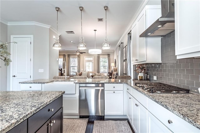 kitchen with visible vents, a center island, decorative backsplash, stainless steel appliances, and wall chimney exhaust hood