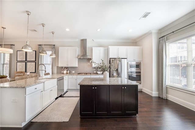 kitchen featuring ornamental molding, dark wood finished floors, a peninsula, wall chimney range hood, and decorative backsplash