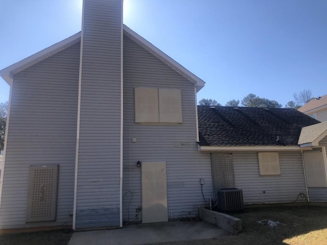 rear view of property with central AC