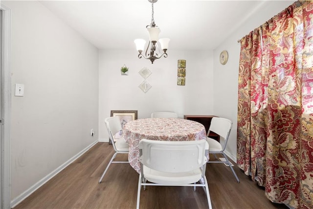 dining space with an inviting chandelier, baseboards, and dark wood-type flooring