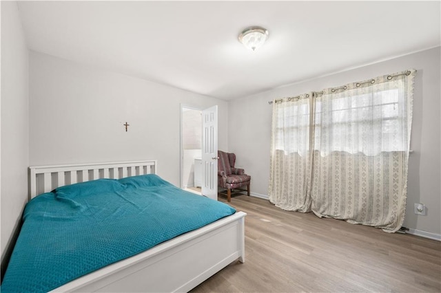 bedroom with baseboards and wood finished floors