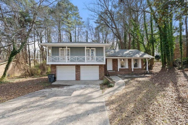 tri-level home with covered porch, concrete driveway, and brick siding