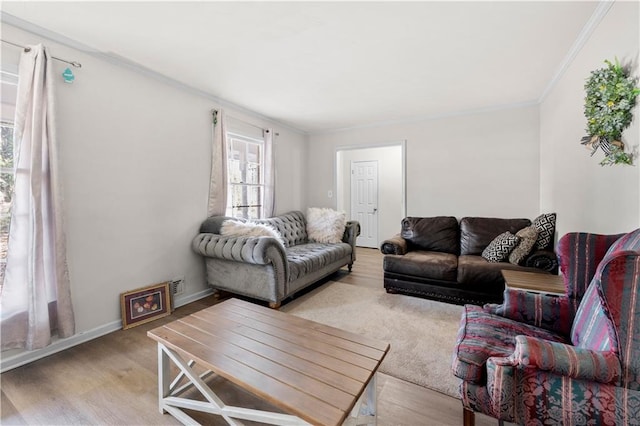 living room featuring light wood-style flooring, baseboards, and crown molding