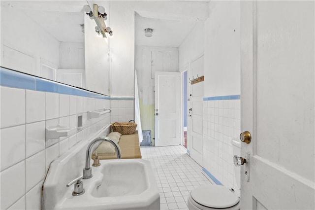 5128 Lavista Rd, Tucker, GA 30084 - bathroom with tile walls, a sink, toilet, tile patterned floors, and wainscoting