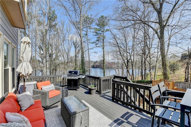 wooden deck featuring outdoor lounge area, a water view, and a grill