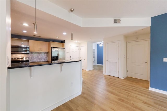 390 17th St NW Unit 2053, Atlanta, GA 30363 - kitchen featuring appliances with stainless steel finishes, a breakfast bar, light wood-style flooring, decorative backsplash, and recessed lighting