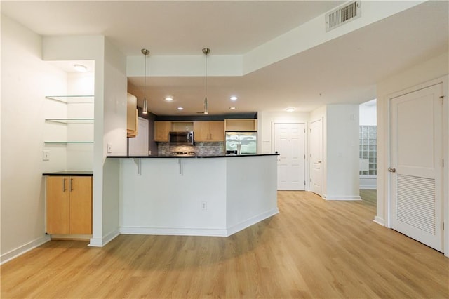 390 17th St NW Unit 2053, Atlanta, GA 30363 - kitchen with stainless steel appliances, dark countertops, light wood-style flooring, a peninsula, and tasteful backsplash