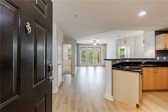 390 17th St NW Unit 2053, Atlanta, GA 30363 - kitchen featuring light wood-style floors, a peninsula, dark countertops, open floor plan, and pendant lighting
