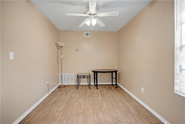 empty room featuring light wood-style floors, visible vents, and baseboards