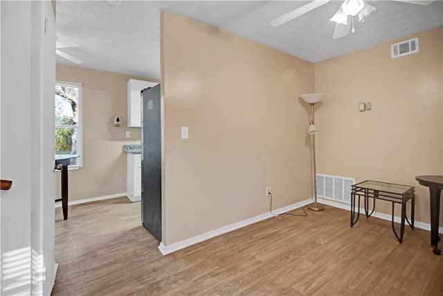 unfurnished room featuring baseboards, visible vents, and light wood finished floors