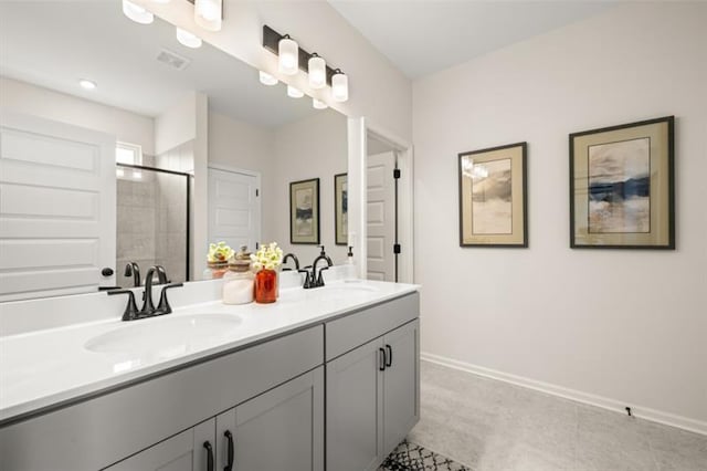 bathroom featuring double vanity, visible vents, a stall shower, a sink, and baseboards