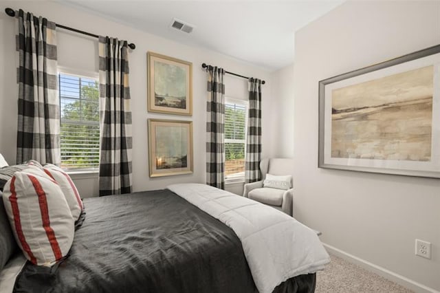 carpeted bedroom featuring visible vents and baseboards