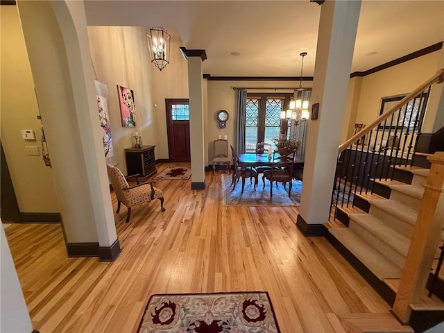 136 Timothy Park Ln, Athens, GA 30606 - entryway featuring a chandelier, crown molding, baseboards, stairway, and light wood-style flooring