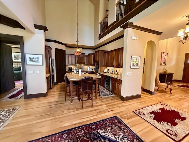 136 Timothy Park Ln, Athens, GA 30606 - kitchen featuring stainless steel appliances, arched walkways, light wood finished floors, dark brown cabinets, and a kitchen bar