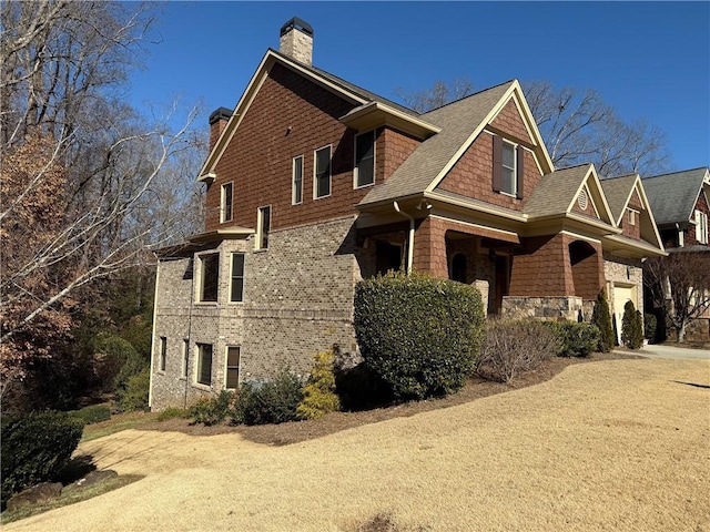 136 Timothy Park Ln, Athens, GA 30606 - view of home's exterior with a chimney, stone siding, and roof with shingles