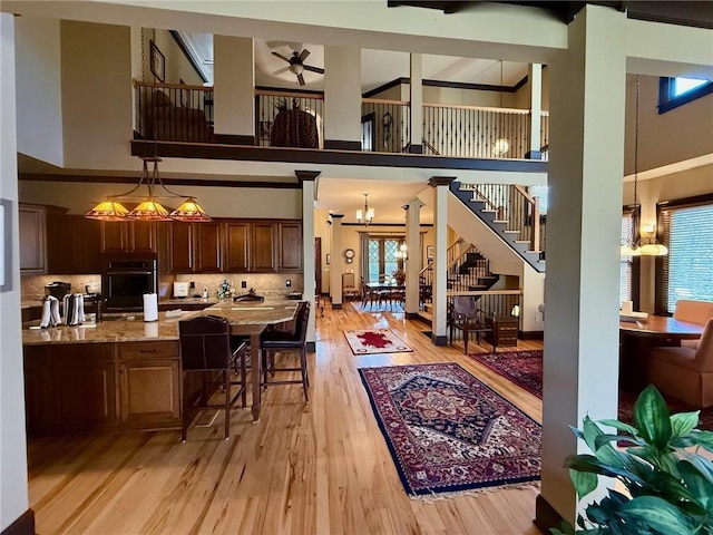 136 Timothy Park Ln, Athens, GA 30606 - interior space with a towering ceiling, a ceiling fan, light wood-style floors, a kitchen bar, and hanging light fixtures