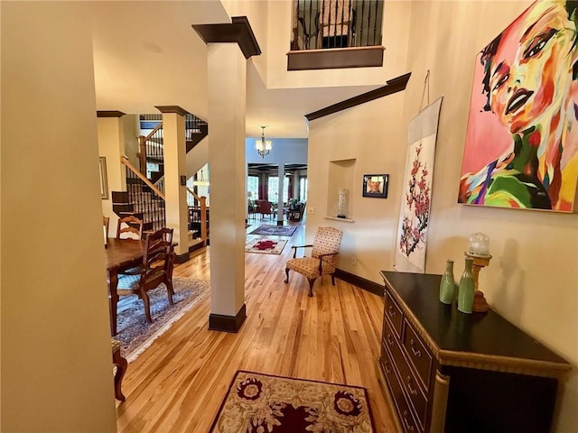 136 Timothy Park Ln, Athens, GA 30606 - hall featuring light wood-type flooring, a high ceiling, a chandelier, baseboards, and stairs