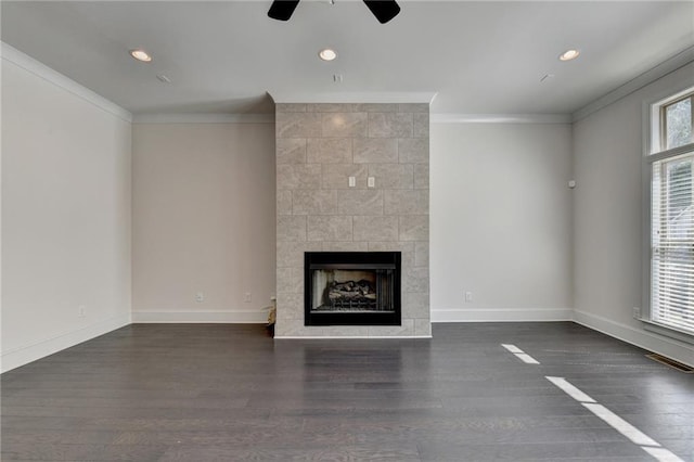 unfurnished living room featuring ceiling fan, a fireplace, dark hardwood / wood-style floors, and crown molding