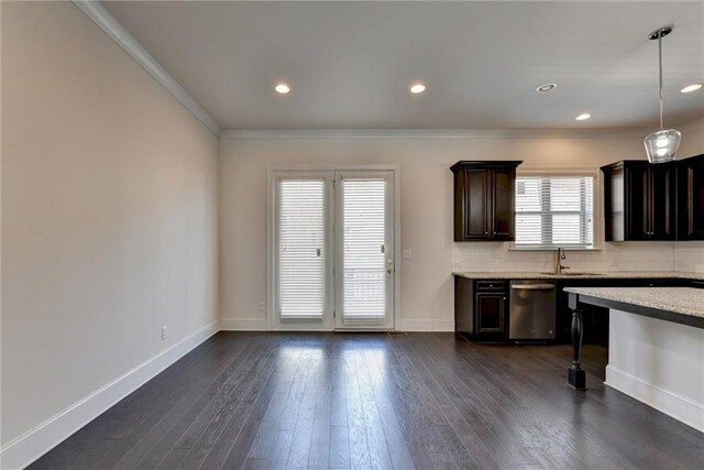 kitchen featuring dark hardwood / wood-style floors, decorative backsplash, hanging light fixtures, ornamental molding, and stainless steel dishwasher