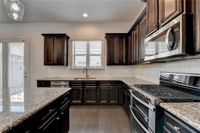 kitchen featuring light stone counters, sink, dark hardwood / wood-style flooring, appliances with stainless steel finishes, and dark brown cabinets