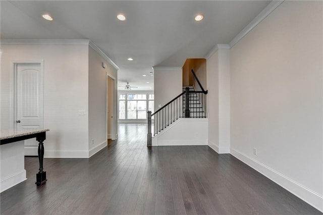 foyer entrance with dark hardwood / wood-style floors, ornamental molding, and ceiling fan