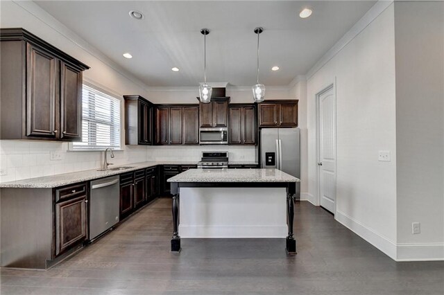 kitchen with dark brown cabinetry, a center island, sink, hanging light fixtures, and appliances with stainless steel finishes