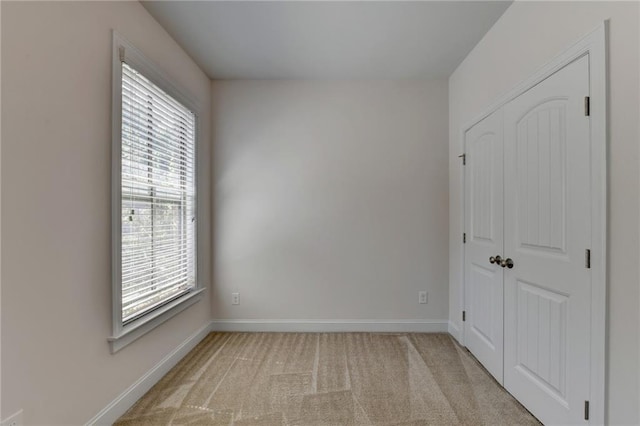 spare room featuring light colored carpet and a healthy amount of sunlight