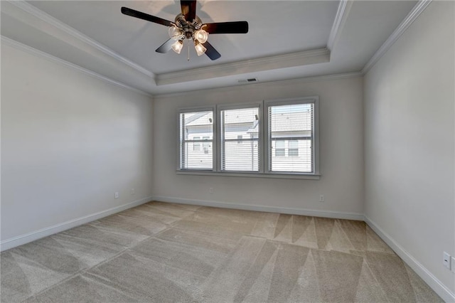 carpeted empty room featuring crown molding, ceiling fan, and a raised ceiling