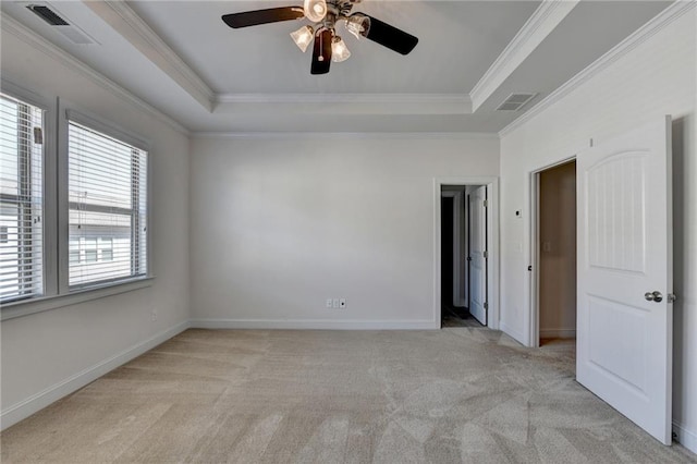 carpeted spare room featuring a raised ceiling, crown molding, and ceiling fan