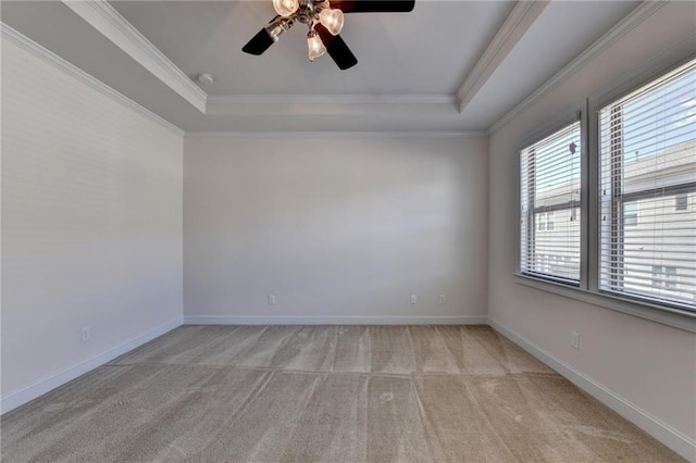 carpeted spare room featuring ceiling fan, a tray ceiling, and ornamental molding