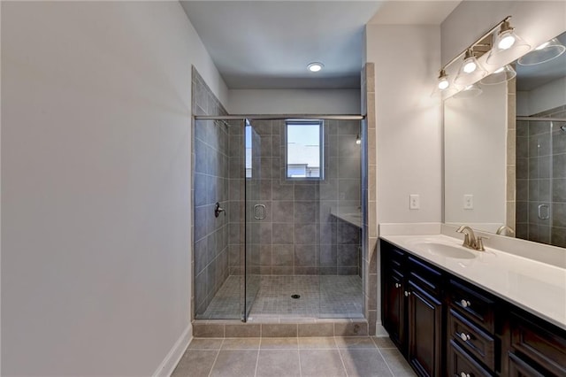 bathroom featuring vanity, a shower with shower door, and tile patterned flooring